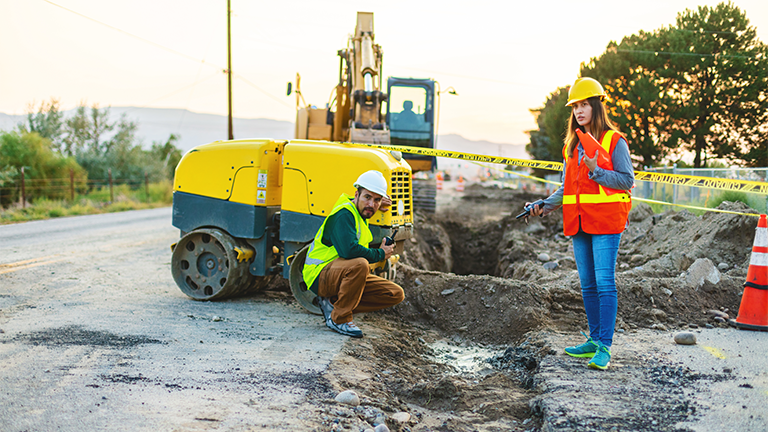 Construction workers looking at road project