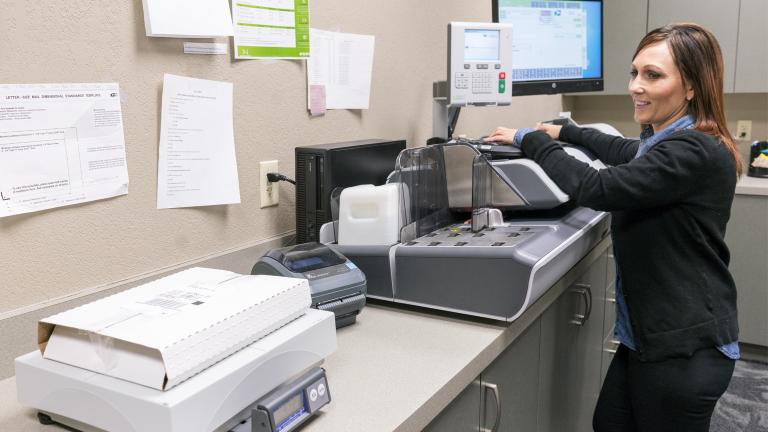 a smiling woman in a working in an office copy room