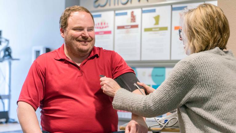 a Sourcewell employee getting a free blood pressure check, which is one of many available wellness initiatives and programs