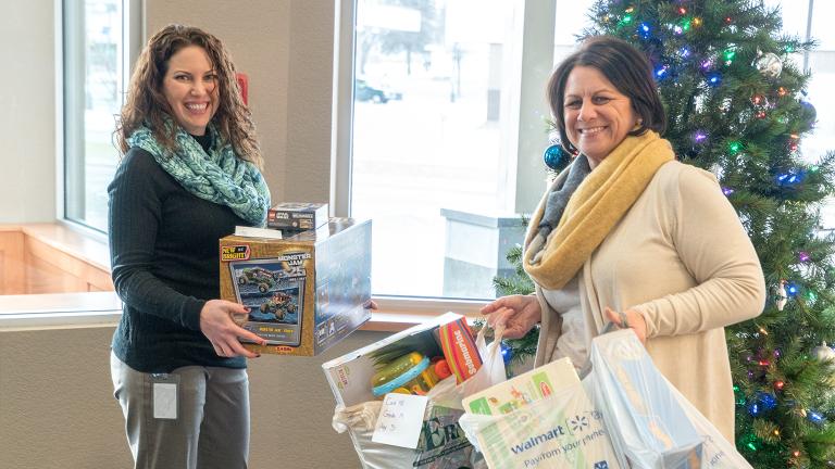Sourcewell Human Resources staff gather holiday gifts and toys donated by employees for a local charity benefiting children