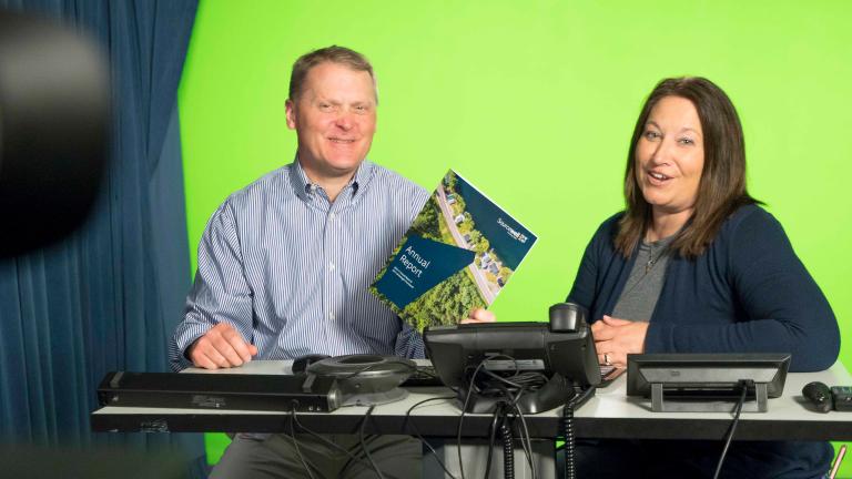 Sourcewell staff in front of a green screen in a studio while presenting a webinar